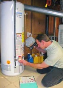 Hayward plumber inspects a water heater during a routine repair